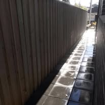 Stone pavers laid along a side path next to a timber fence